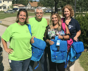 Genisys and Macomb Community Action Staff with Donated Backpacks